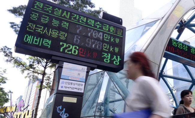 Pedestrians pass an electronic display in Gangnam, southern Seoul, which shows the nation's power reserves. (Park Hae-mook/The Korea Herald)