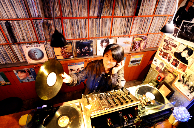 Kim Ik-ha, owner and DJ of Hongdae LP bar The Car with Two Tires, plays an LP record selected by a customer from his collection of thousands of records. (Park Hyun-koo/The Korea Herald)