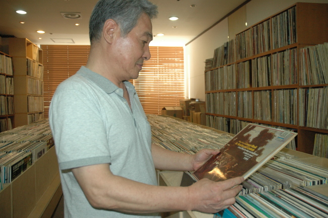 Kim Won-sik, owner of Phil Records in Yongsan, Seoul, looks through a collection of classical music LP records in his shop. (Cha Yo-rim/The Korea Herald)