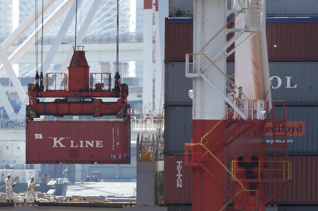 A Kawasaki Kisen Kaisha Ltd. “K” Line shipping container is loaded onto a container ship at a shipping terminal in Yokohama, Kanagawa prefecture, Japan, Sunday. (Bloomberg)