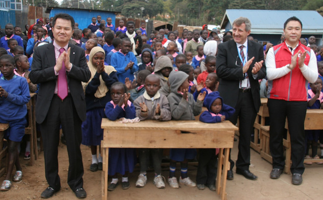 LG Electronics opened its LG Hope School in Kibera, Kenya, on Aug. 12. U.N. WFP’s Kenyan office vice head Paul Turnbull (second from right), LG Electronics’ Kenyan office vice head Kim Jung-jin (left) and LG’s CSR manager Kim Min-seok (right) celebrate with children. (LG Electronics)