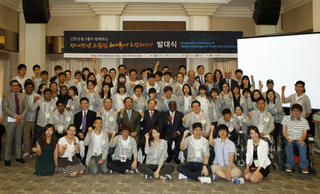 Shinhan Financial Group chairman Han Dong-woo (fourth from left, second row) attends a ceremony to launch an overseas training program for youth with disabilities in Seoul on Wednesday. (Shinhan Financial Group)