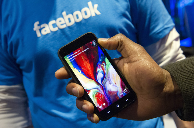 A Facebook Inc. employee holds a phone running the new Home program at the company’s headquarters in Menlo Park, California. ( Bloomberg)