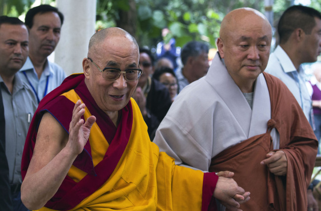 Tibetan spiritual leader the Dalai Lama (front, left) greets devotees as he arrives at the Tsuglakhang Temple to give a religious talk in Dharmsala, India, on Sunday. The three-day talk requested by a Buddhist group from Korea ended Tuesday. (AP-Yonhap News)