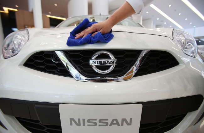 A salesperson cleans the front of a Nissan Motor Co. vehicle on display at the Siam Motor Sales dealership in Bangkok. (Bloomberg)