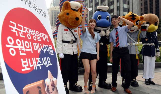 People pose with soldiers dressed as mascots of the different branches of the armed forces to promote Armed Forces Day, which falls on Oct. 1. South Korea’s military is celebrating its 65th anniversary this year. (Ahn Hoon/The Korea Herald)