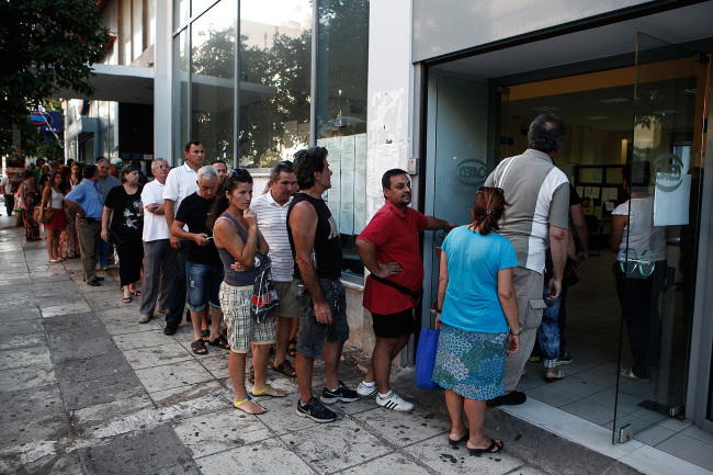 Jobseekers line up to enter a Labor Force Employment Organization job center soon after opening in Athens. (Bloomberg)