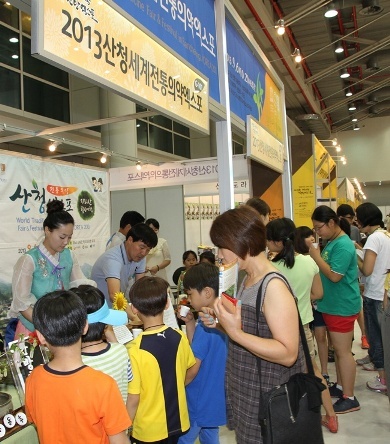 Visitors at the 2013 Korea Oriental Medicine Expo, held in Daegu in June, drink medicinal tea at the booth set up by the organizers of the World Traditional Medicine Fair and Festival. (WTMFF)