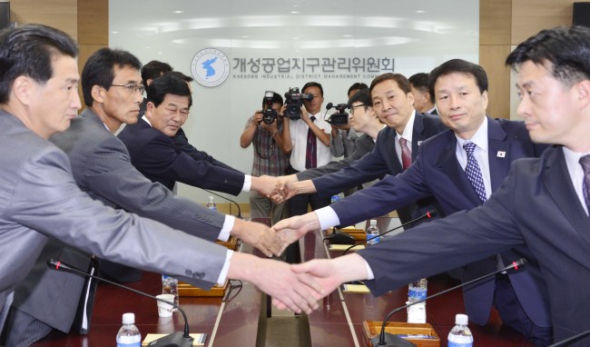 South Korea’s chief delegate Kim Ki-woong (right, third row) and his counterpart Park Chol-su shake hands during their talks in Gaeseong, North Korea, Monday. (Joint Press Corps)