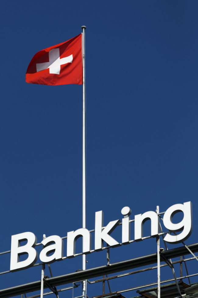 A Swiss national flag flies from the roof of the Bank Hapoalim Ltd. private banking offices in Geneva. (Bloomberg)