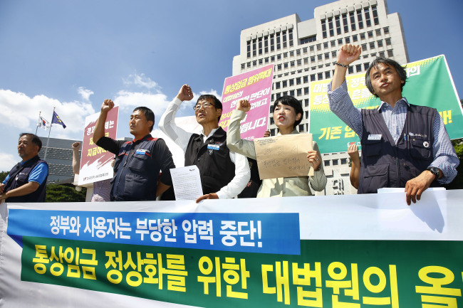 Ahead of a Supreme Court hearing on Thursday over the ordinary wage system, the Korean Confederation of Trade Unions holds a rally outside the court on Wednesday (bottom photo) and representatives of the Korea Chamber of Commerce and Industry submit a petition to the court Tuesday to make their respective cases. (Yonhap News)