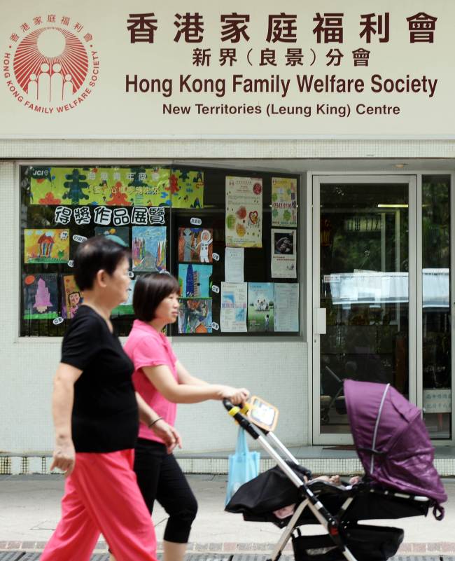 People walk past a Hong Kong Family Welfare Society office in Hong Kong on July 31. (AFP-Yonhap News)