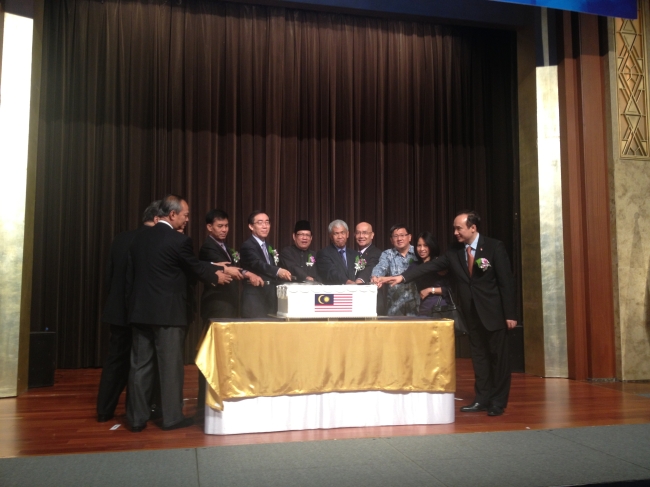 Malaysian Ambassador to South Korea Dato’ Ramlan bin Ibrahim (center) and Korean guests and envoys from Southeast Asian nations pose for the cameras in a cake-cutting ceremony during a National Day reception at a hotel in Seoul on Tuesday. (Philip Iglauer/The Korea Herald)