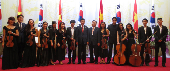 Park Sam-koo (center), chairman of Kumho Asiana, poses with recipients of its scholarships shortly after their concert at a state dinner in Hanoi, Vietnam, Monday. (Kumho Asiana)