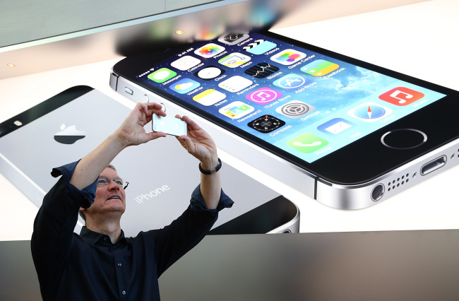 Apple CEO Tim Cook uses an iPhone to take a picture of customers waiting in front of an Apple store in Palo Alto, California, to purchase the new iPhones on Sept. 20. (AFP-Yonhap News)