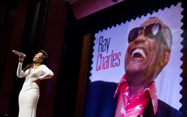 A stamp featuring musician Ray Charles is unveiled as singer Ashanti performs at the event at Morehouse College in Atlanta on Monday. (AP-Yonhap News)