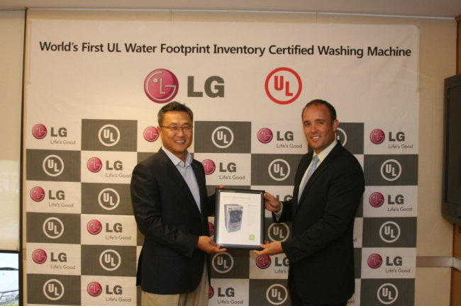 Jung Kyu-hwang (left), head of LG U.S home appliances, and Donald Mayer,a marketing official from Underwriters Laboratories, pose with the water footprint certification in New Jersey on Sept. 13. (LGE)