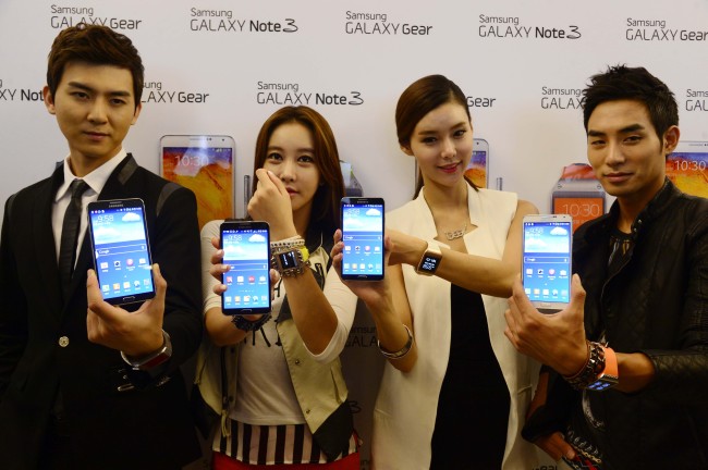 Models pose with Samsung Electronics’ latest phablet Galaxy Note 3 and smart watch Gear at a launch in Seoul on Wednesday. (Park Hae-mook/The Korea Herald)