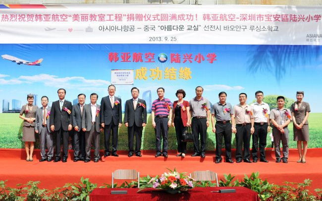 Asiana Airlines CEO Yoon Young-doo (sixth from left) and local government and school officials pose during a ceremony at Luxing Elementary School in Shenzhen City, Guangdong province, Wednesday. (Asiana Airlines)