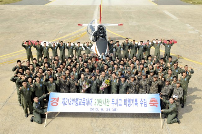 Members of the 213th Flying Training Squadron of the 3rd Training Wing of the Air Force pose in front of a KT-1 aircraft, showing a banner to celebrate the record of flying 200,000 hours without an accident. (Air Force)