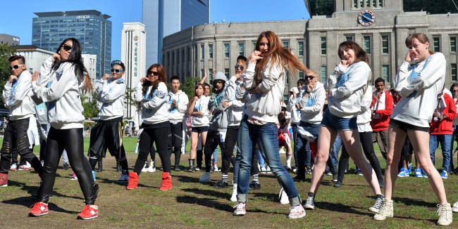 The finalists of the K-Pop Festival in PyeongChang stage a flash mob performance outside Seoul City Hall on Thursday. The festival is designed to promote tourism in connection to the 2018 PyeongChang Winter Olympics. (Lee Sang-sub/The Korea Herald)