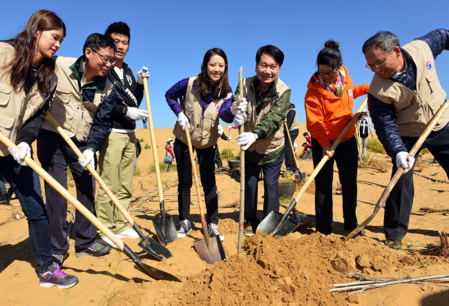 Korean Air CEO Ji Chang-hoon (third from right) and employees pose during an annual tree-planting event in the Kubuqi Desert in China’s Inner Mongolia on Thursday. (Kim Myung-sub/The Korea Herald)