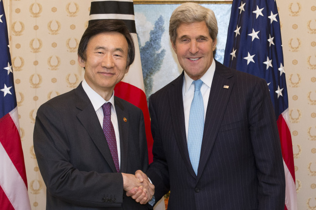 Foreign Minister Yun Byung-se (left) shakes hands with U.S. Secretary of State John Kerry at the onset of their talks in New York on Friday on the sidelines of the U.N. General Assembly. (Yonhap News)