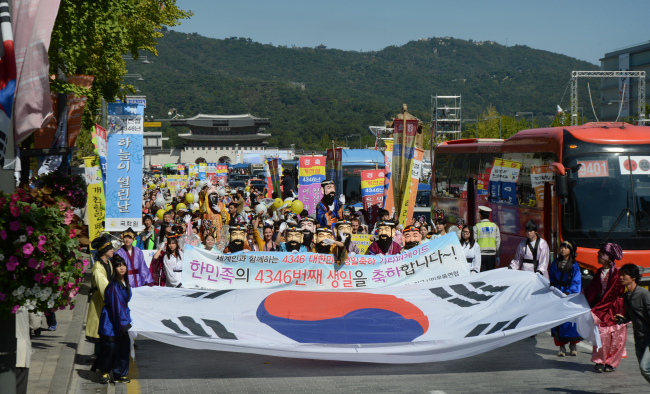 Performers wearing masks of Dangun, the legendary founding father of Korea, and other mythical characters lead a National Foundation Day parade on the street in front of Gwanghwamun, Seoul, Thursday. (Chung Hee-cho/The Korea Herald)