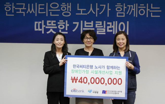 Citibank Korea’s communication division head Oh Young-ran (left) poses after delivering a donation of 40 million won ($36,000), jointly raised by labor and management, to social foundation Sarangbat at the financial firm’s headquarters in downtown Seoul on Friday. (Citigroup Korea)