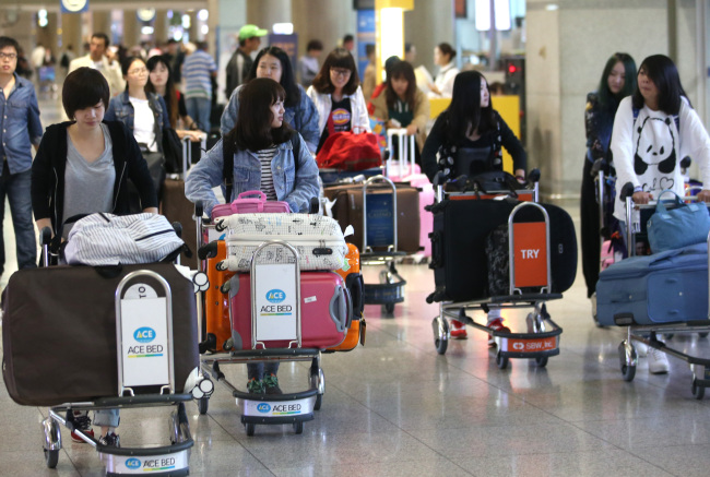 Chinese tourists arrive at Incheon International Airport on Sept. 29, ahead of China’s “Golden Week” public holiday from Oct. 1-7. The Chinese government has published a 64-page “Guidebook for Civilized Tourism” to educate its citizens against inappropriate behavior when abroad ahead of the country’s biggest holiday season. (Yonhap News)