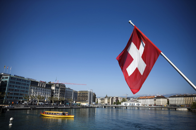 A Swiss national flag flies from a flagpole above Lake Geneva. (Bloomberg)