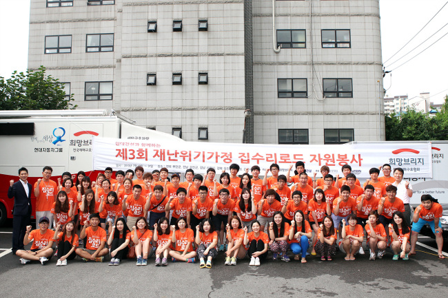 A student volunteer team organized by Hyundai E&C poses before participating in a project to repair disaster-prone houses. (Hyundai E&C)