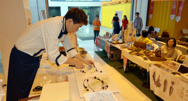 Chef Kim Yong-hui demonstrates creative plating at the Herald Design Market’s Food Deco Show.(Kim Myung-sub/The Korea Herald)