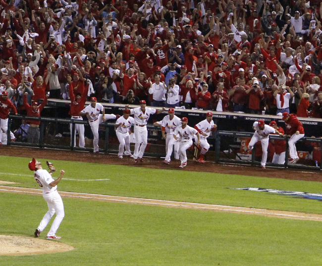 Cardinals players rush toward starting pitcher Adam Wainwright after the final out of Game 5. (AP-Yonhap News)