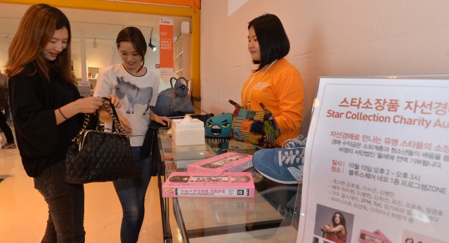 Visitors make a bid for items donated by celebrities at a charity auction held Thursday as part of Herald Design Week 2013 at exhibition space NEMO at Blue Square, Hannam-dong, Seoul. (Lee Sang-sub/The Korea Herald)