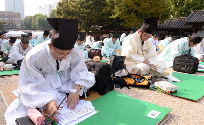 Applicants compose poems in Chinese in reenactment of Joseon era (1392-1910) tests to select senior officials, held by the Seoul Metropolitan Government in Unhyeongung Palace in the Jongno district on Sunday. (Ahn Hoon/The Korea Herald)