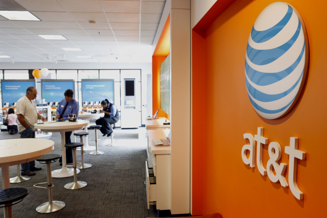 An employee helps a customer at an AT&T Inc. store in Manhattan Beach, California. (Bloomberg)