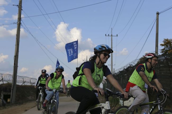 Korea Exchange Bank officials and expat customers participate in the “DMZ & Peace Bicycle Tour” near the inter-Korean Demilitarized Zone on Sunday. The tour is a part of KEB’s “Omega Service” designed to help its international customers understand Korean history. (KEB)