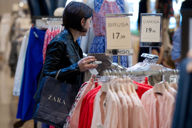 A customer inspects clothes on display inside a Mango fashion store in Barcelona. (Bloomberg)