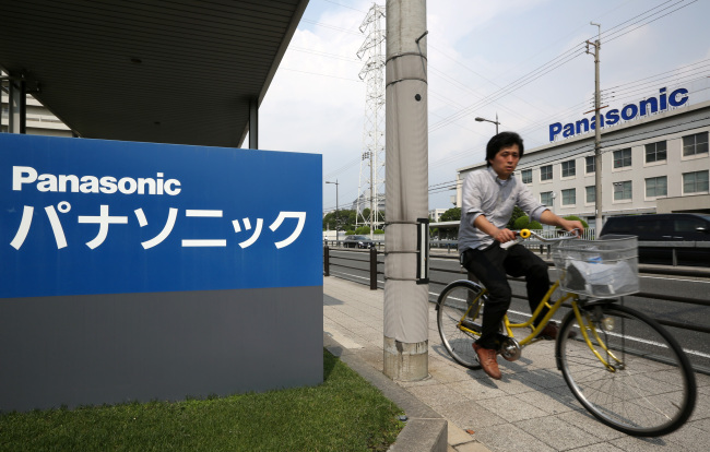 A man rides a bicycle past the Panasonic Corp. headquarters in Kadoma, Japan. (Bloomberg)