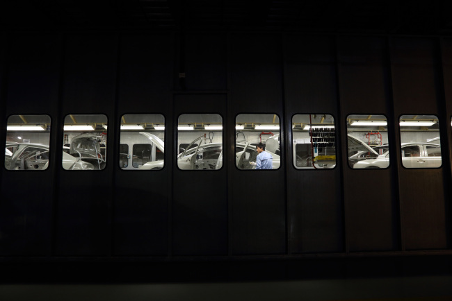 A worker prepares to paint a vehicle at a plant operated by Dongfeng Peugeot-Citroen Automobile Ltd. in Wuhan, China. (Bloomberg)