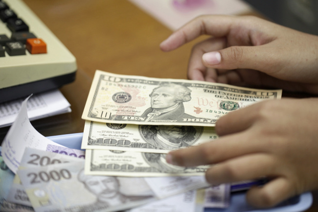 A clerk counts Indonesian rupiah and U.S. dollar banknotes at a currency exchange office in Jakarta. (Bloomberg)