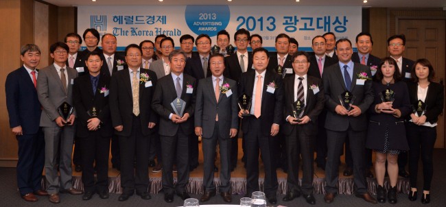 Herald Corp. publisher and CEO Lee Young-man (center, front row) poses with the winners of The Korea Herald Advertising Awards for this year at the award ceremony in Seoul on Thursday. SK Corp. won the grand prize with its advertisement about its social contribution activities. (Lee Sang-sub/The Korea Herald)