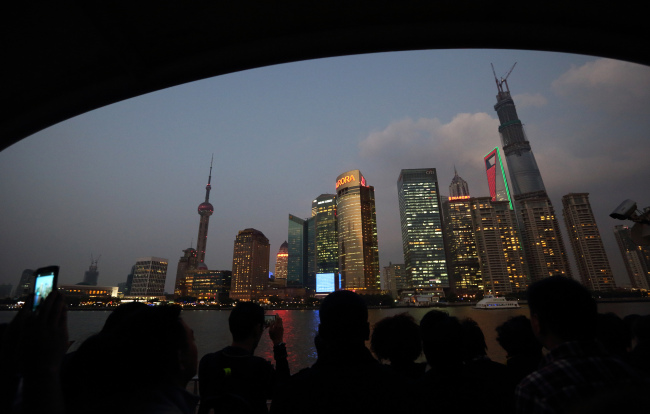 Passengers on a ferry look at buildings in the Lujiazui district of Shanghai. (Bloomberg)