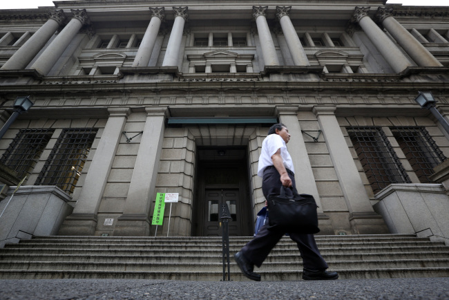 A pedestrian walks past the Bank of Japan headquarters in Tokyo. (Bloomberg)