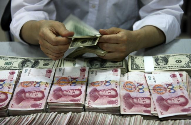 U.S. dollar notes being counted next to stacks of Chinese 100 yuan notes at a bank in Huaibei, China.(AFP-Yonhap News)