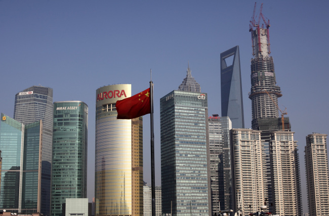 China’s national flag flies in front of commercial buildings in the Pudong area of Shanghai. (Bloomberg)