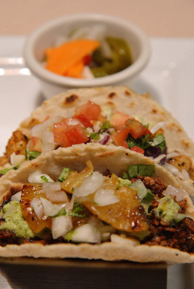 Coreanos Kitchen’s al pastor pork (front) and grilled shrimp tacos are swaddled in handcrafted tortillas made from masa. (Lee Sang-sub/The Korea Herald)