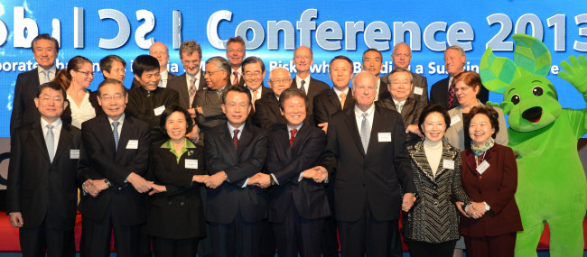 Lee Seung-han (fifth from left, front row), president of U.N. Global Compact Korea and chairman of Homeplus, joins hands with participants, including former Prime Minister Han Seung-soo (fourth from left, front row), chairman of the organizing committee for the conference, during the Global CSR Conference 2013 that kicked off in Seoul for a two-day run on Tuesday. (Lee Sang-sub/The Korea Herald)