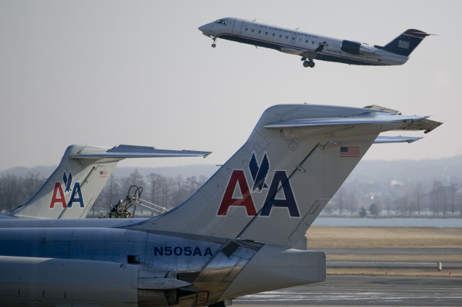 A US Airways Group Inc. airplane takes off behind AMR Corp.’s American Airlines airplanes at Reagan National Airport in Washington, D.C. (Bloomberg)